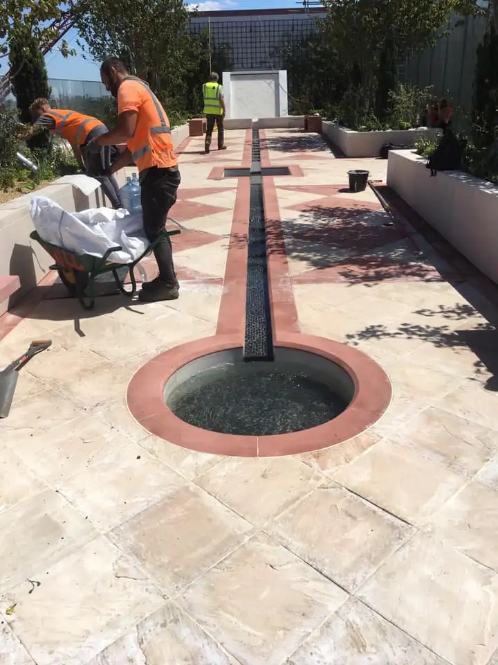 BGH team laying paving around a water feature