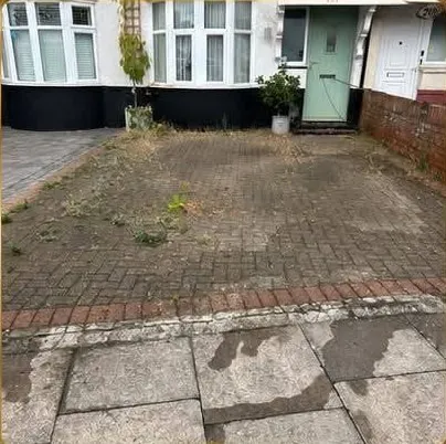 Block paving driveway with weeds and dirt before jetwashing